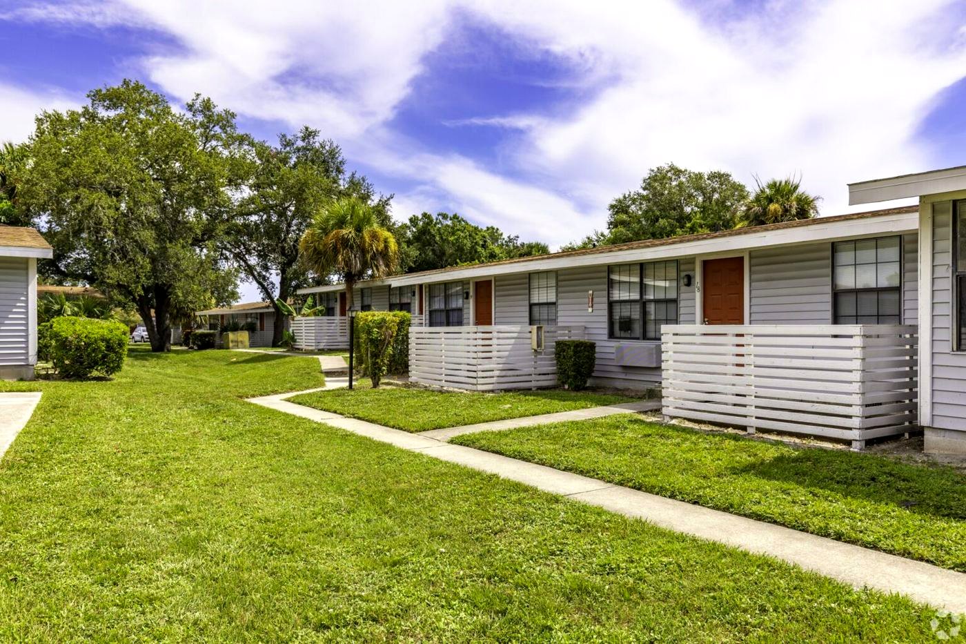 Single-story Palm Harbor Villas apartment homes with lawns and walkways