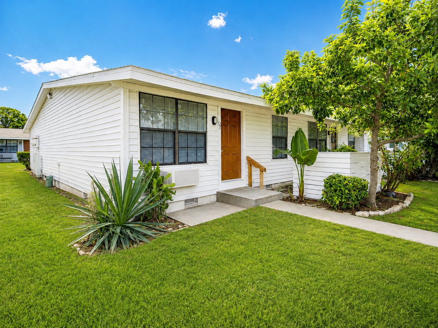 Single-story Palm Harbor Villas home with private front entry, fresh landscaping and lawn