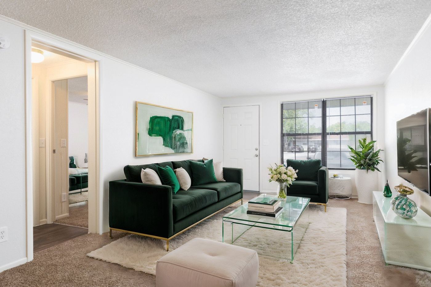 Staged living room with sofa and large windows in a Palm Harbor Villas apartment