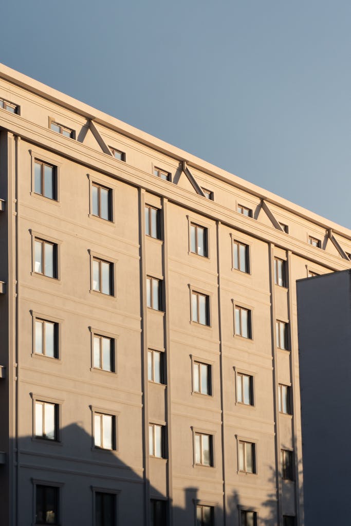 Modern urban building facade captured during golden hour with clear sky.